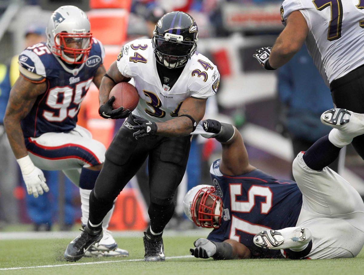 Baltimore Ravens running back Ricky Williams runs between New England Patriots defenders Jan. 22 during the AFC Championship.