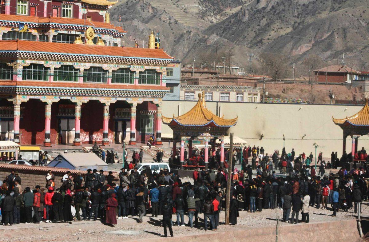 Hundreds of Tibetans gather Wed. on the side of a main street in Nangqian county, China, to watch as a Tibetan man set himself on fire in protest of government policies.