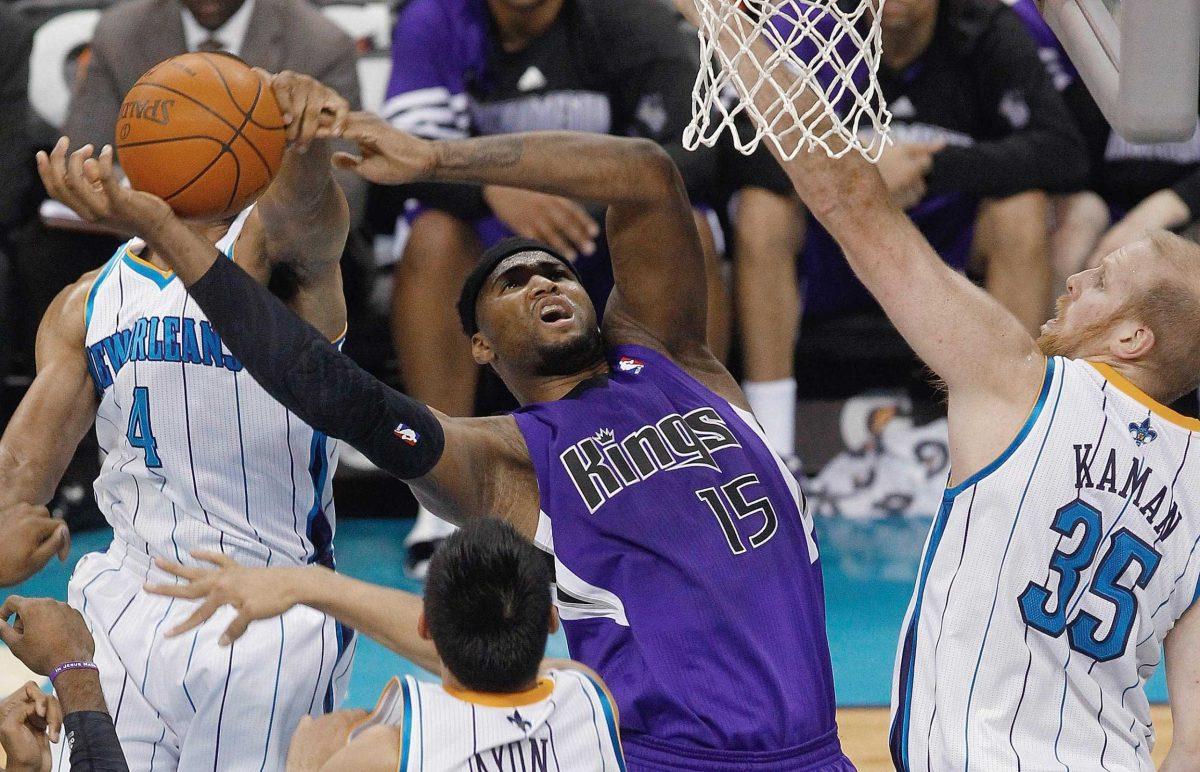 Sacramento Kings forward DeMarcus Cousins (15) goes to the basket as he is fouled by New Orleans Hornets guard Xavier Henry (4) as Hornets center Chris Kaman (35) defends during the first half of an NBA basketball game in New Orleans, Monday, Feb. 6.