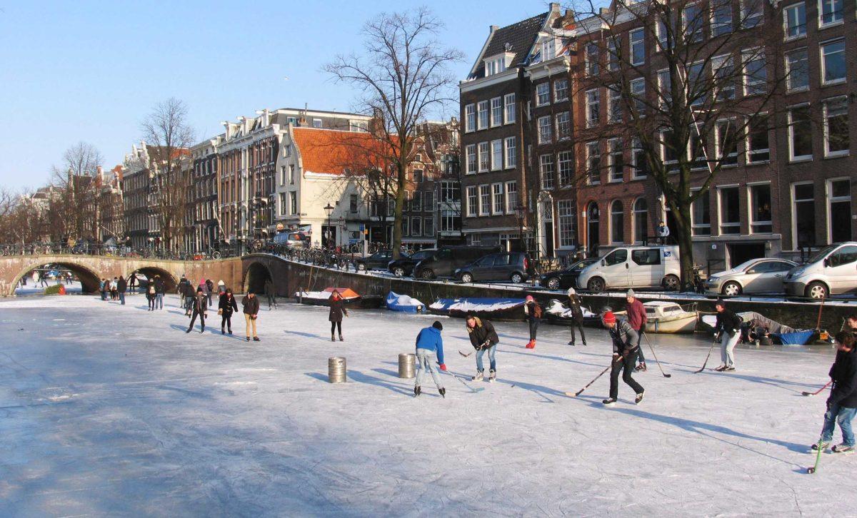 Youths play ice hockey Tuesday in Amsterdam, Netherlands. Volunteers pour out to frozen rivers and lakes to shovel away snow, bettering chances for a skating race.