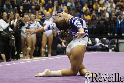 The LSU gymnastics team cheers as freshman gymnast Rheagan Courville completes her floor exercise Friday during the Tigers&#8217; meet against Alabama in the PMAC.