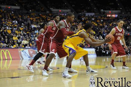 LSU senior forward Storm Warren (24) tries to get past Alabama defenders Feb. 12 during the game against Alabama in the PMAC. The Tigers won, 67-58.