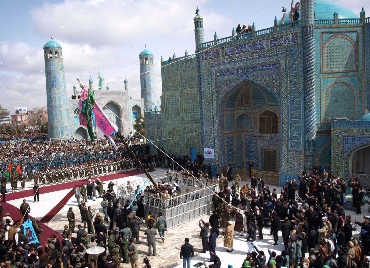 Afghan men raise the holy mace Tuesday during Nowruz, a celebration of the Persian New Year, at the Imam Ali&#8217;s shrine in Afghanistan.