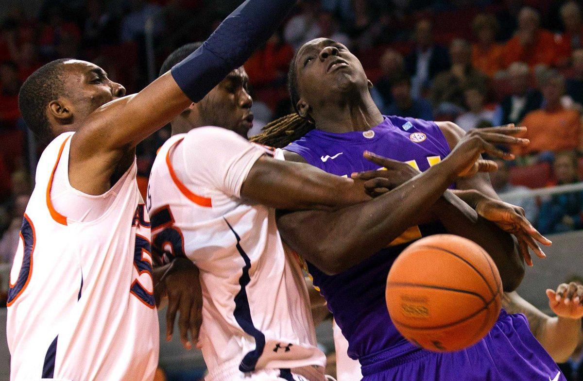 LSU forward Johnny O&#8217;Bryant III is fouled by Auburn&#8217;s Adrian Forbes, center, and Willy Kouassi, left, during the game Saturday in Auburn, Ala. The Tigers lost, 67-52.