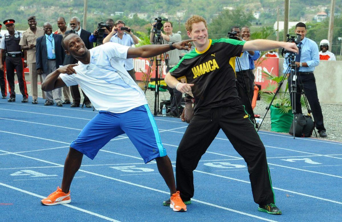 Britain&#8217;s Prince Harry, right, and Olympic sprinter Usain Bolt pose Bolt&#8217;s landmark gesture after a mock race Tuesday in Kingston, Jamaica.