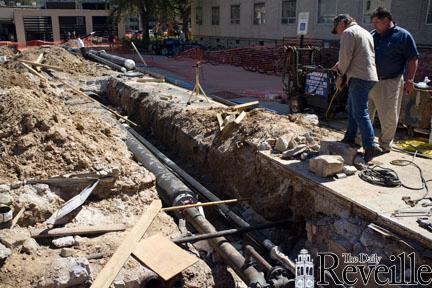 Workers examine the construction to fix safety and energy issues caused by steam leaking from pipes near Acadian Hall. The repairs are nearly complete.