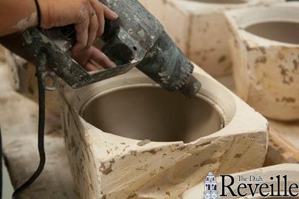 A student dries an unfinished bowl in its mold on Wednesday as part of Clare Twomey&#8217;s project to make 1,000 bowls.