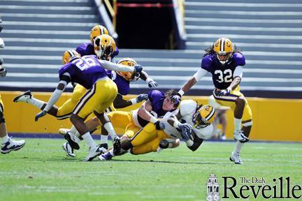 LSU running back Spencer Ware, wearing white, gets tackled Saturday in the 2012 National L-Club Spring Football Game in Tiger Stadium.