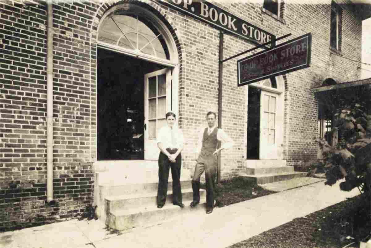 Co-op Bookstore founder W.A. Prescott (left) stands outside his store&#8217;s original location on West Chimes Street.