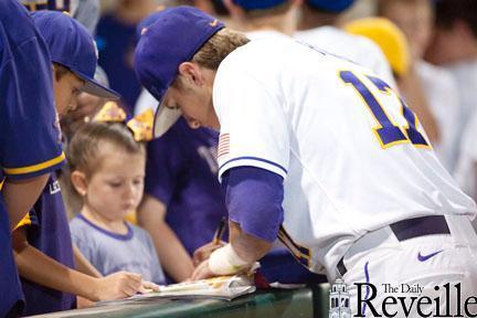 Freshman infielder Jared Foster signs autographs March 30 for young fans after the Tigers&#8217; 10-6 win against Arkansas in Alex Box Stadium.