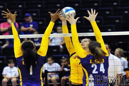 Freshmen Khourtni Fears (1) and Cati Leak (24) attempt to block a spike from freshman Katie Lindelow (7) in the Purple and Gold Scrimmage Saturday at the PMAC.