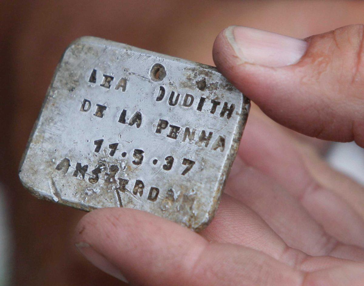 Archaeologist Yoram Haimi shows an aluminum plate to students at the site of the former German Nazi death camp of Sobibor, in eastern Poland, on Tuesday.