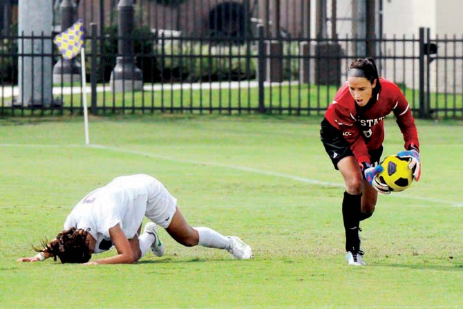 LSU freshman midfielder Fernanda Pi&#241;a (7) falls down in distress after North Carolina State sophomore goalkeeper Victoria Hopkins (0) blocks her shot on goal in the final seconds of the Lady Tigers' game against the Wolfpack on Sunday in the LSU Soccer Stadium.
 