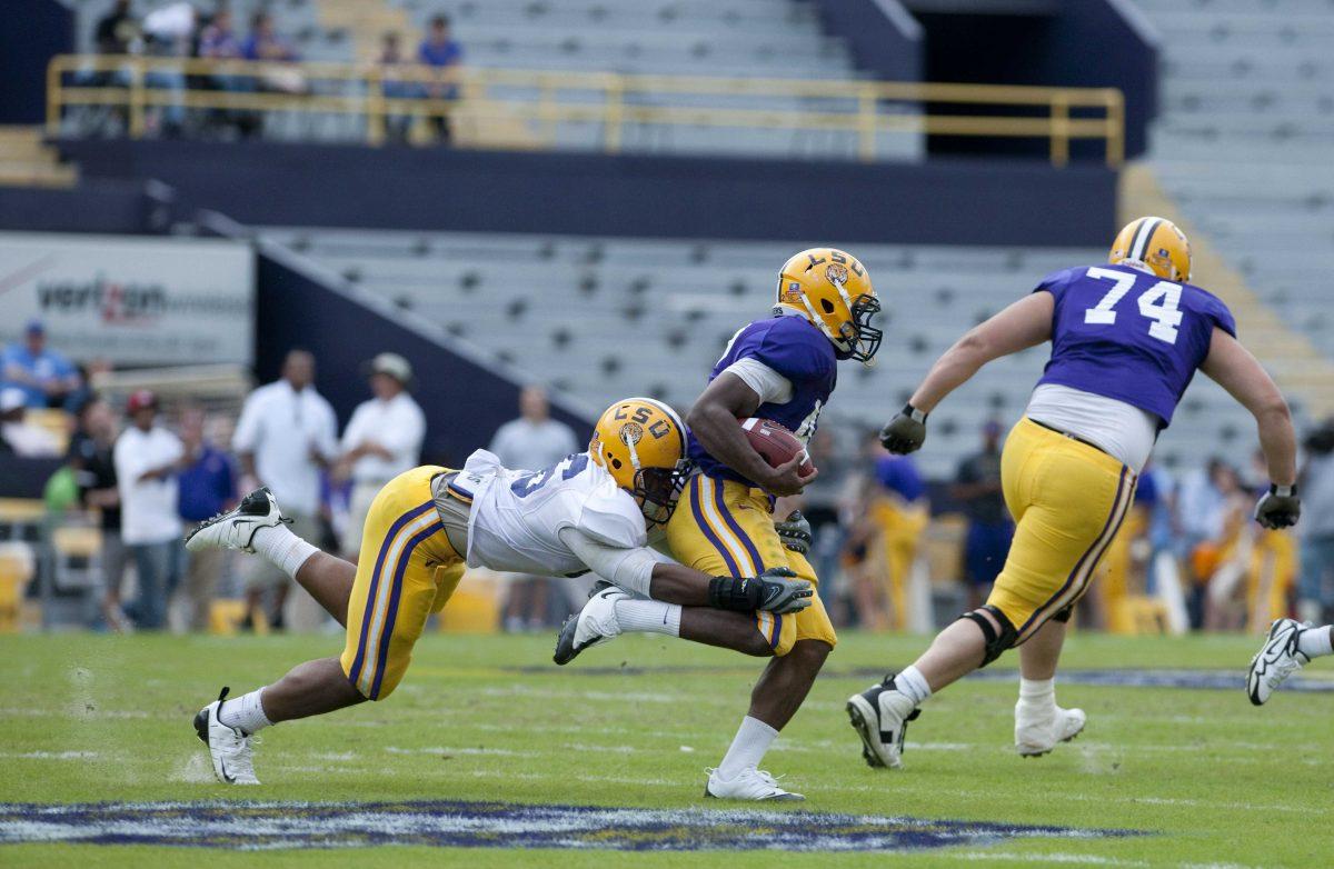 Freshman linebacker Kevin Minter (46) attempts to tackle freshman running back Michael Ford (42) in the National L Club spring football game on Saturday.