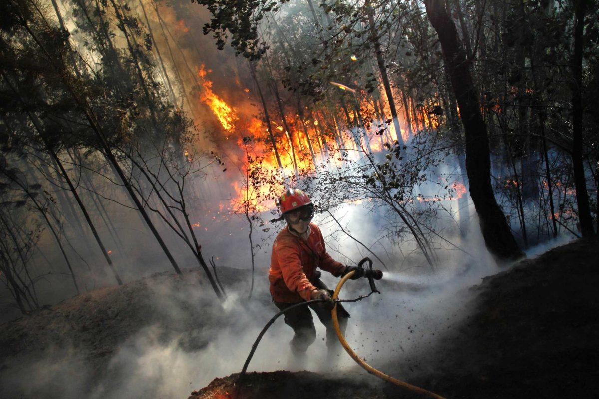 A firefighter steps back while working to douse a fire in Alvaiazere, Portugal, on Tuesday.