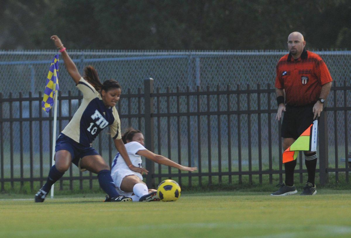 A referee prepares to make the call as LSU senior midfielder Natalie Ieyoub and Florida International University sophomore midfielder Scarlett Montoya fight for the ball Friday during the Tigers&#8217; 0-0 tie against FIU.