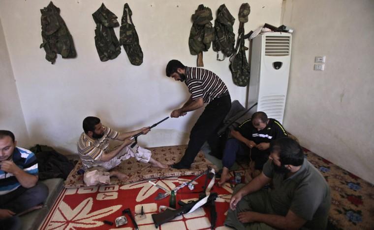 In this Tuesday, Sept. 4, 2012, photo, a Syrian rebel fighter helps a comrade to clean a weapon in a house in Marea, on the outskirts of Aleppo, Syria. Rebels have taken a major stride in uniting their ranks in the battle for Syria&#8217;s largest city, giving them hope they could tip the balance in three-months of bloody stalemate in Aleppo, one of the biggest prizes of the civil war.. The question is how much more destruction the city can bear. Regime troops are retaliating with heavier bombardment, and civilians are bearing the brunt, their neighborhoods left in rubble. (AP Photo/Muhammed Muheisen)
 