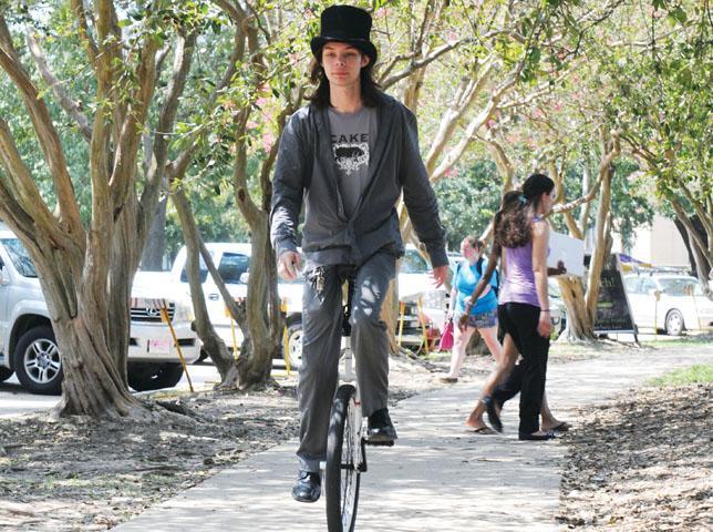 Adam Barnes, communication studies sophomore, balances on his unicycle Wednesday in front of the Student Union. He started offering unicycle riding lessons.