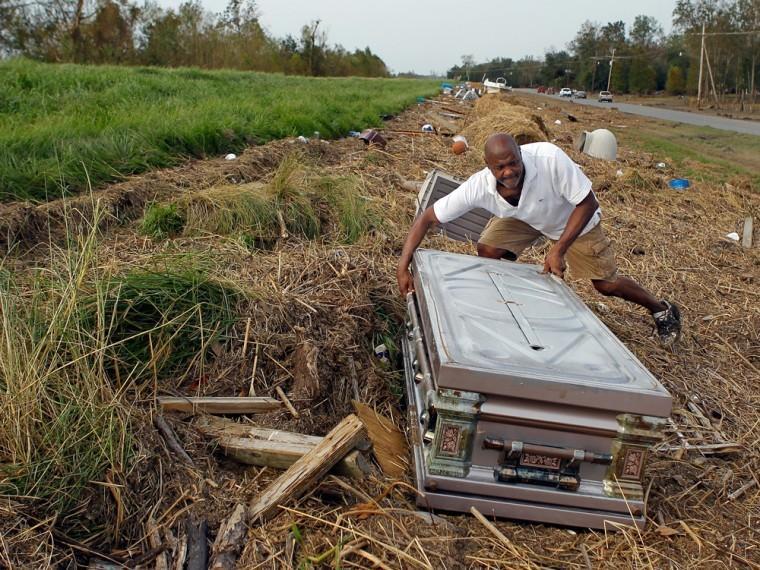 Dwight Robinson, 59, looks for the casket of his mother, Irma LeBlanc Robinson, on the Mississippi River levee, Wednesday, Sept. 5, 2012. She died in 1995 at the age of 81 and was buried in the Bertrandville Cemetery in Plaquemines Parish. Hurricane Isaac and its 15 of storm surge decimated that cemetery and floated caskets and crypts at least a quarter mile. (AP Photo/The Times-Picayune, David Grunfeld) MAGS OUT; NO SALES; USA TODAY OUT
 