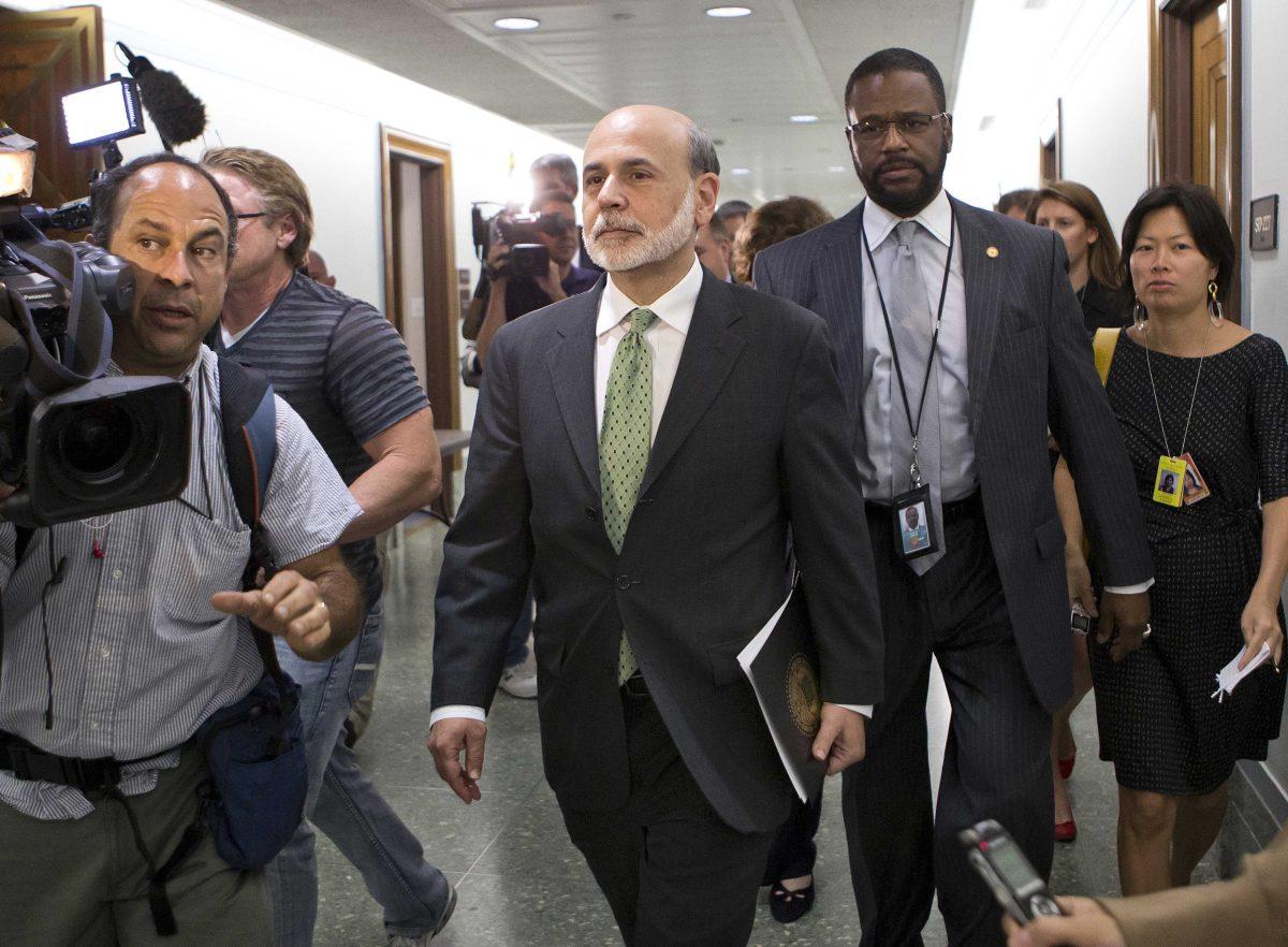 Federal Reserve Chairman Ben Bernanke makes his way past reporters on Capitol Hill after meeting privately with Senate Finance Committee Chairman Max Baucus, D-Mont., and members of the committee about the looming economic crisis, often called the "fiscal cliff", on Capitol Hill in Washington, Wednesday, Sept. 19, 2012. (AP Photo/J. Scott Applewhite)