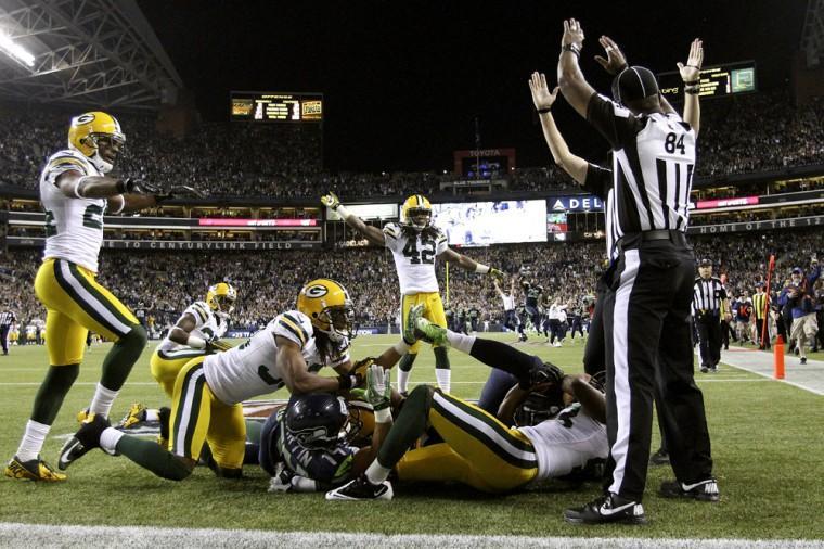 Officials signal after Seattle Seahawks wide receiver Golden Tate pulled in a last-second pass from quarterback Russell Wilson to defeat the Green Bay Packers 14-12 in an NFL football game, Monday, Sept. 24, 2012, in Seattle. The touchdown call stood after review. (AP Photo/The Seattle Times, John Lok) MAGS OUT; NO SALES; SEATTLEPI.COM OUT; MANDATORY CREDIT; USA TODAY OUT; TV OUT
 