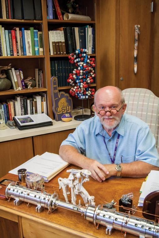 Professor and chemist Steven Barker sits at his desk, surrounded by curious objects &#8212; a mortar and pestle, a DNA model, the cylinder of a spectrometer.
 