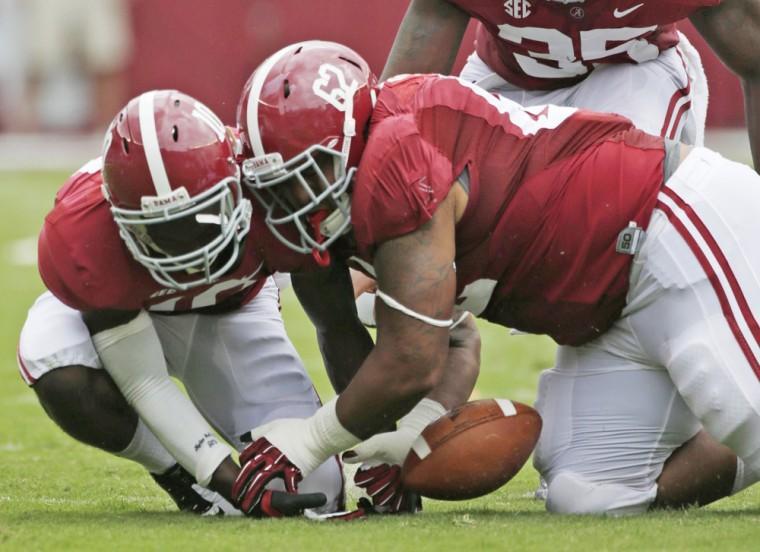 FILE - In this Sept. 8, 2012, file photo, Alabama defensive lineman Brandon Ivory (62) battles with teammate John Fulton (10) for a Western Kentucky fumble in the first half of an NCAA college football game at Bryant Denny Stadium in Tuscaloosa, Ala. Alabama coaches had one statistic they could really gripe about with last season's defense: It forced few turnovers, and only three fumbles. The coaches visited NFL and college teams with that knack during the offseason and the top-ranked Crimson Tide has already induced seven turnovers in two games headed into Saturday's game at Arkansas. (AP Photo/Dave Martin, File)
 