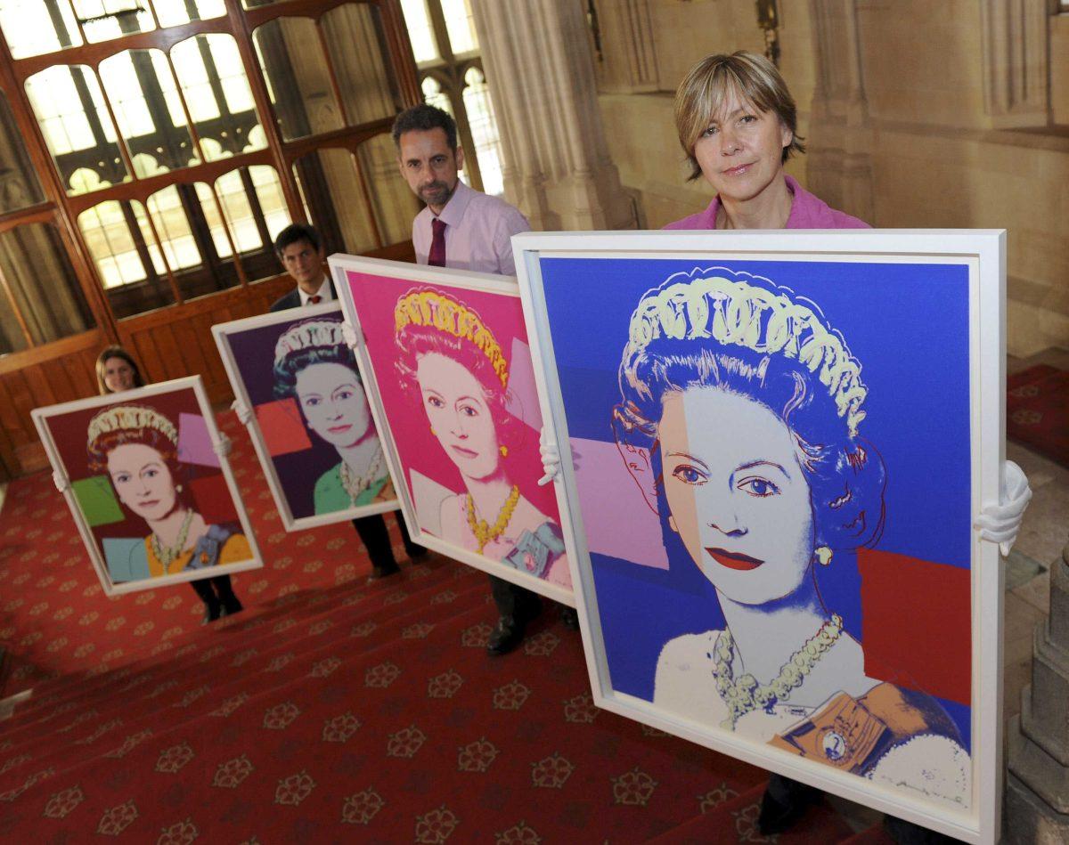 Exhibition curator Lauren Porter, left, and Royal Collection staff Allan Chinn, second left, Martin Clayton, second right, and Kate Stone stand with four Andy Warhol portraits of Queen Elizabeth II in Windsor Castle, Windsor, England, Monday Sept. 24, 2012, that will form part of the "Portraits of a Monarch" exhibit starting in November at Windsor Castle until June 2013. The colorful screenprints are based on a formal photograph of the queen wearing a tiara and necklace that was used during her Silver Jubilee celebrations in 1977. (AP Photo/PA, Andrew Matthews) UNITED KINGDOM OUT NO SALES NO ARCHIVE