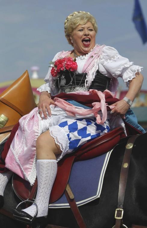 Rider 'Braeurosl' from the Munich brewery celebrates during the Oktoberfest folklore parade through the city, during the famous Bavarian "Oktoberfest" beer festival in Munich, southern Germany, Sunday, Sept. 23, 2012. The world's largest beer festival, to be held from Sept. 22 to Oct. 7, 2012 will see some million visitors. (AP Photo/Matthias Schrader)
 