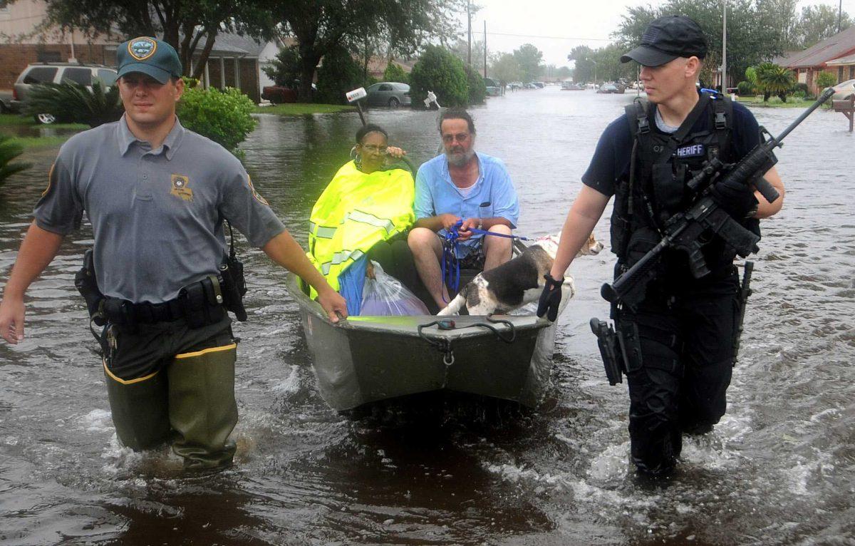 Louisiana Wildlife and Fisheries Sr. Agent Wesley Duck, left, and St. John Parish Sheriff Deputy Jason Raborn rescue Bernita and David Augustine and their dog Ella from the their home in the Cambridge Neighborhood in LaPlace, La., Thursday, Aug. 30, 2012. Isaac soaked Louisiana for yet another day and pushed more water into neighborhoods all around the city, flooding homes and forcing last-minute evacuations and rescues. (AP Photo/The Advocate, Arthur D. Lauck) MAGS OUT; INTERNET OUT; NO SALES; TV OUT; NO FORNS; LOUISIANA BUSINESS INC. OUT (INCLUDING GREATER BATON ROUGE BUSINESS REPORT, 225, 10/12, INREGISTER, LBI CUSTOM)