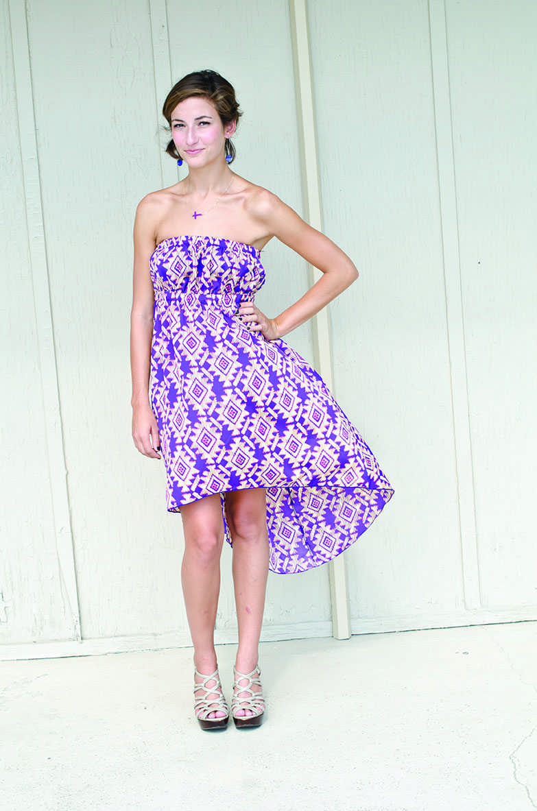 Mariel Jones wearing a Purple printed high-low dress ($42) and a purple cross neclace ($30) both from Vertigo