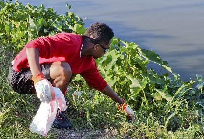 Erin Drye (right), Baton Rouge Magnet High senior, picks up trash around the LSU Lakes with Keep Baton Rouge Beautiful Saturday morning.
 