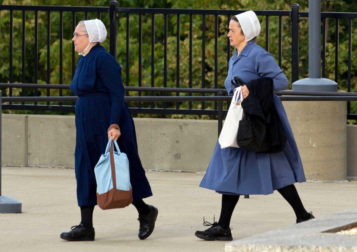 Two Amish women walk to the U.S. Federal Courthouse in Cleveland on Thursday, Sept. 20, 2012. The jury will begin their fifth day of deliberations in the trial of 16 Amish people accused of hate crimes in hair- and beard-cutting attacks against fellow Amish in Ohio. (AP Photo/Scott R. Galvin)