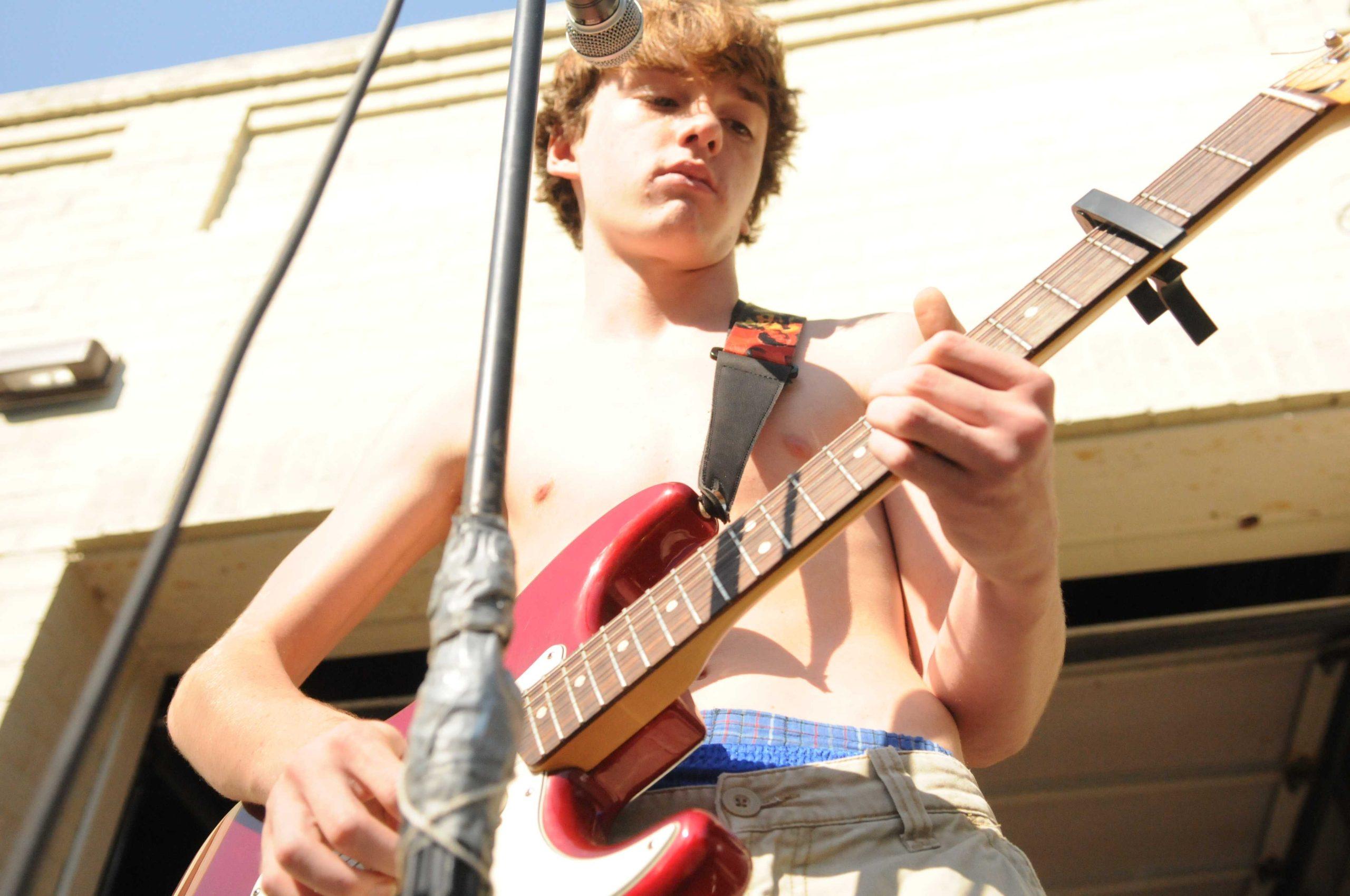 Shirtless high school band serenades drivers on Highland