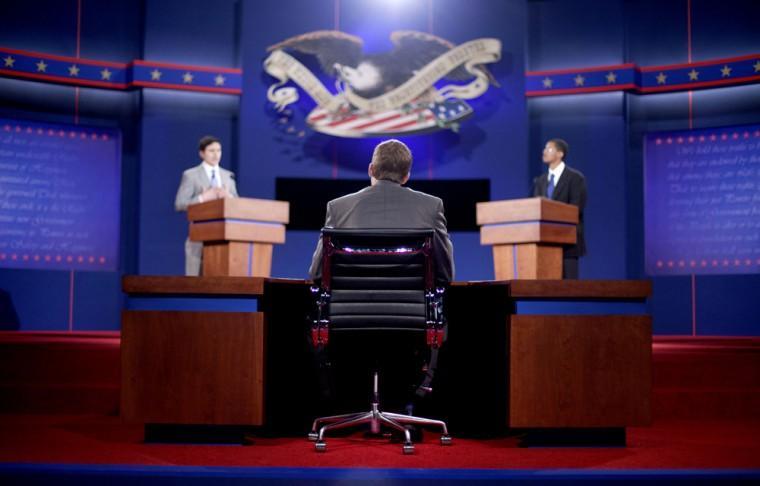 Stand-ins for moderator Jim Lehrer, center, Republican presidential candidate, former Massachusetts Gov. Mitt Romney, left, and President Barack Obama, right, run through a rehearsal for a debate at the University of Denver Tuesday, Oct. 2, 2012, in Denver. President Barack Obama and Republican presidential candidate and former Massachusetts Gov. Mitt Romney will hold their first debate Wednesday. (AP Photo/David Goldman)
 