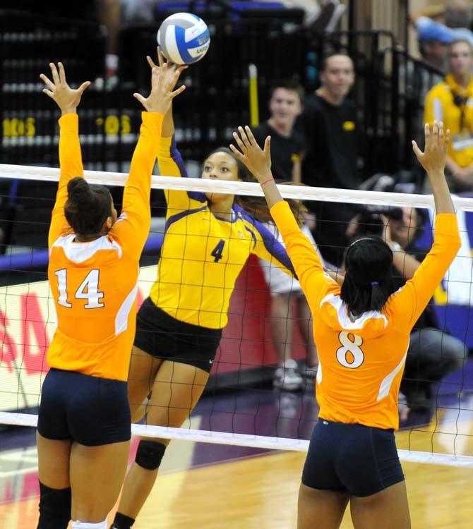 Junior middle blocker Desiree Elliot spikes the ball between two Tennessee defenders during a game against the Volunteers on October 10, 2012.
 