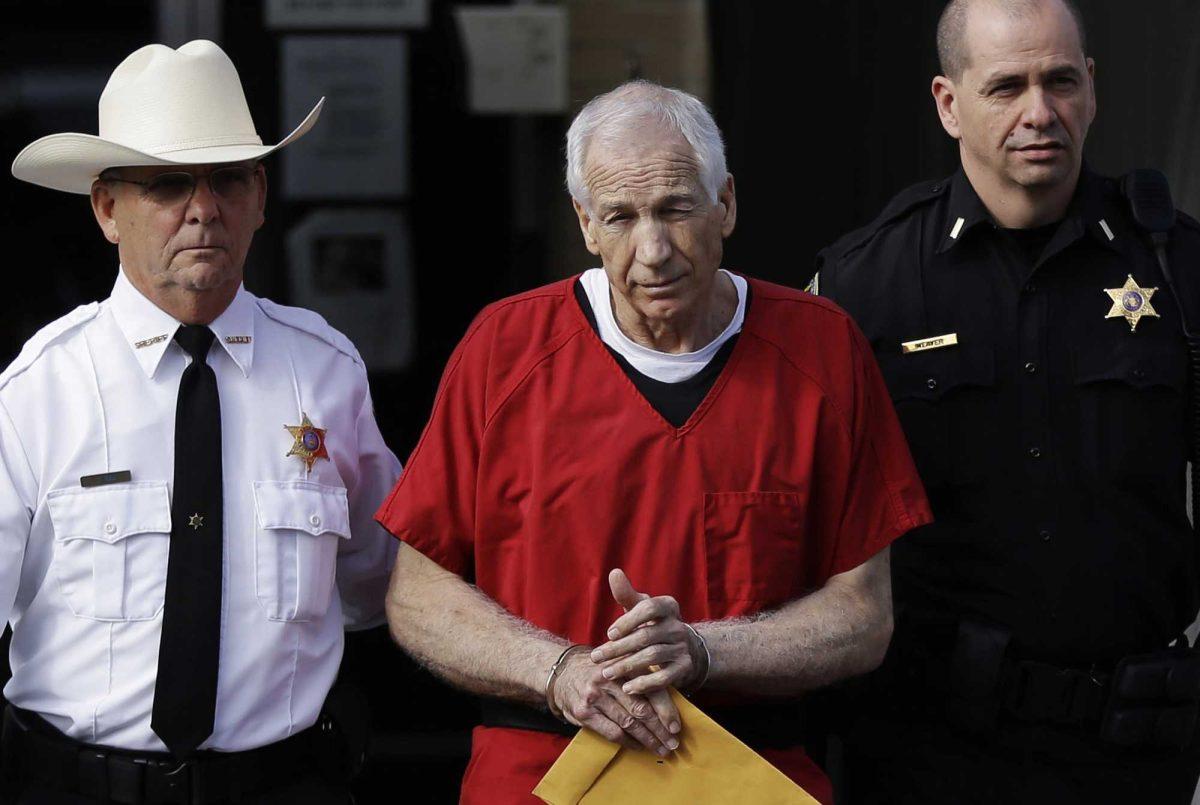 Former Penn State University assistant football coach Jerry Sandusky, center, is taken from the Centre County Courthouse by Centre County Sheriff Denny Nau, left, and a deputy, after being sentenced in Bellefonte, Pa., Tuesday, Oct. 9, 2012. Sandusky was sentenced to at least 30 years in prison, effectively a life sentence, in the child sexual abuse scandal that brought shame to Penn State and led to coach Joe Paterno's downfall. (AP Photo/Matt Rourke)