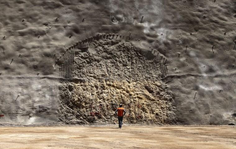 In this Sept. 25, 2012 photo, a worker from the National Copper Mine Corporation, or Codelco, looks at the area where a new tunnel is marked to be drilled at the Chuquicamata copper mine in the Atacama desert in northern Chile. Experts say that by 2019 the Chuquicamata copper mine will be unprofitable, so state-owned mining company Codelco is trying to head off closure by converting the open pit into the world's largest underground mine. Codelco believes the mine still has much more to give, with reserves equal to about 60 percent of all the copper exploited in the mine's history still buried deep beneath the crater. (AP Photo/Jorge Saenz)
 