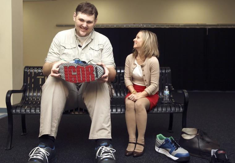 Igor Vovkovinskiy of Rochester, Minn, the tallest person living in America, speaks with WCCO reporter Holly Wagner about his new custom made size 24 Reebok Shoes Thursday, October 18, 2012 at the Rochester Athletic Club in Rochester, Minn. Vovkovinskiy, who is 7 feet 8.33 inches tall, was given three pairs of shoes from Reebok, each sporting IGOR logos. (AP Photo/Rochester Post-Bulletin, Michele Jokinen)
 