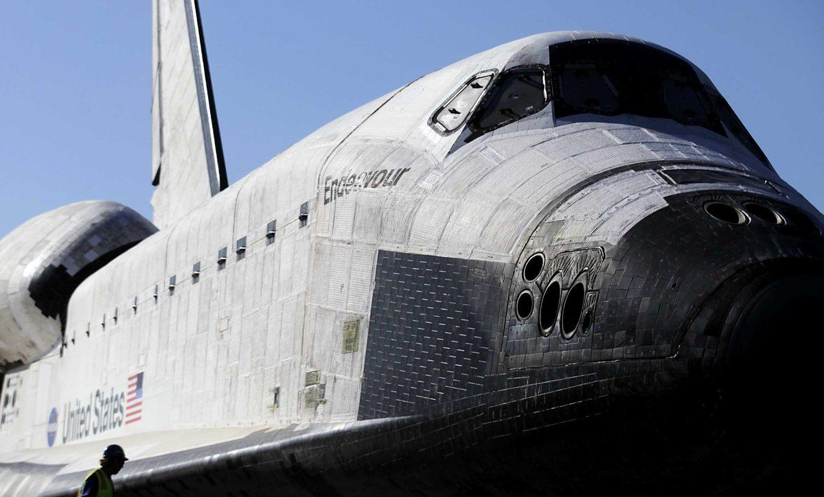 A workman helps in the process of prepping the space shuttle Endeavour to move the final few yards into a temporary hangar at the California Science Center in Los Angeles on Sunday, Oct. 14, 2012. After a 12-mile (19-kilometer) weave past trees and utility poles that included thousands of adoring onlookers, flashing cameras and even the filming of a TV commercial, Endeavour arrived at the California Science Center Sunday to a greeting party of city leaders and other dignitaries that had expected it many hours earlier. (AP Photo/Los Angeles Times, Luis Sinco, Pool)