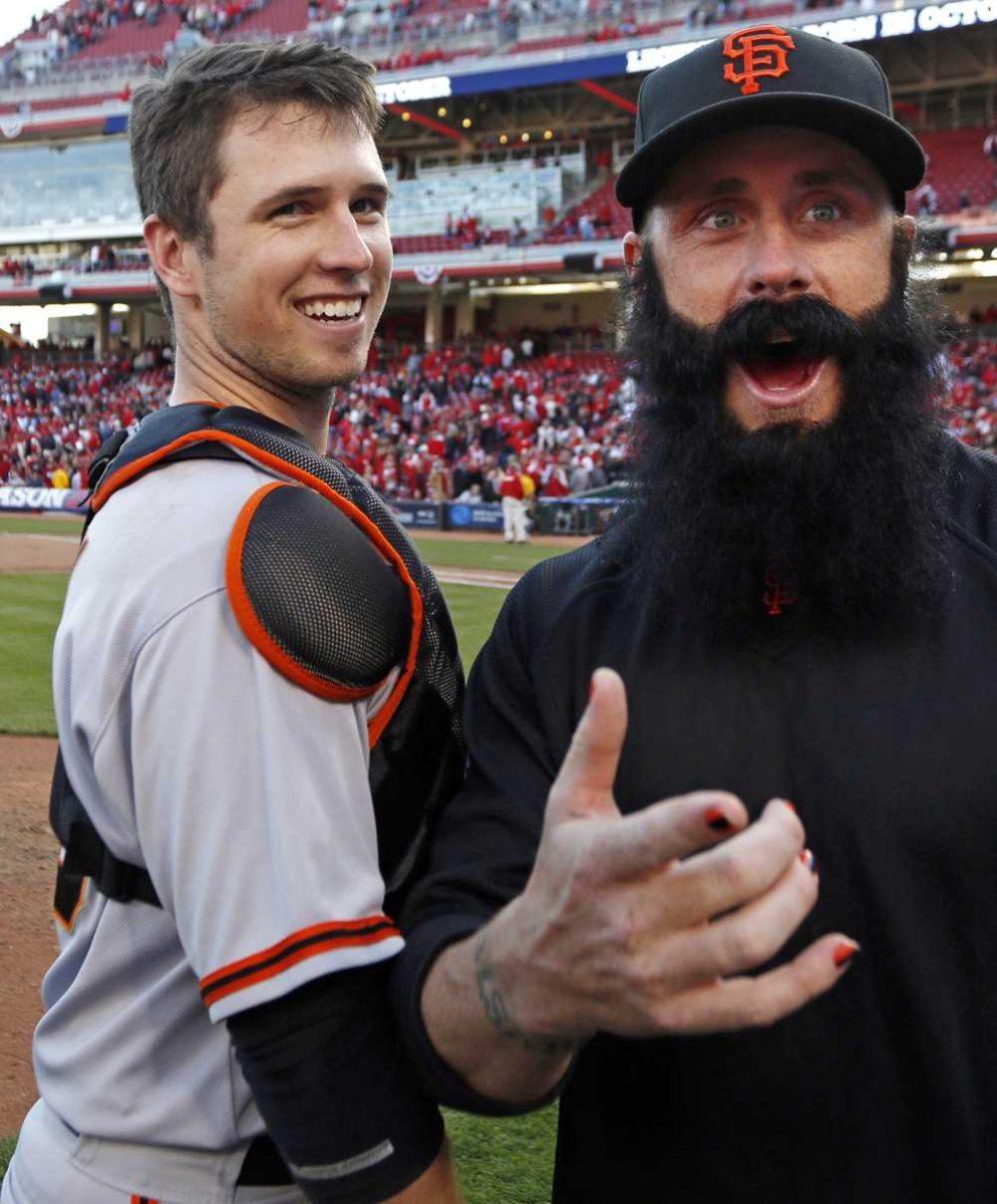 San Francisco Giants' Buster Posey celebrates with pitcher Brian Wilson after they defeated the Cincinnati Reds 6-4 in Game 5 of the National League division baseball series, Thursday, Oct. 11, 2012, in Cincinnati. The Giants won the final three games, all in Cincinnati, and advanced to the NL championship series. (AP Photo/David Kohl)