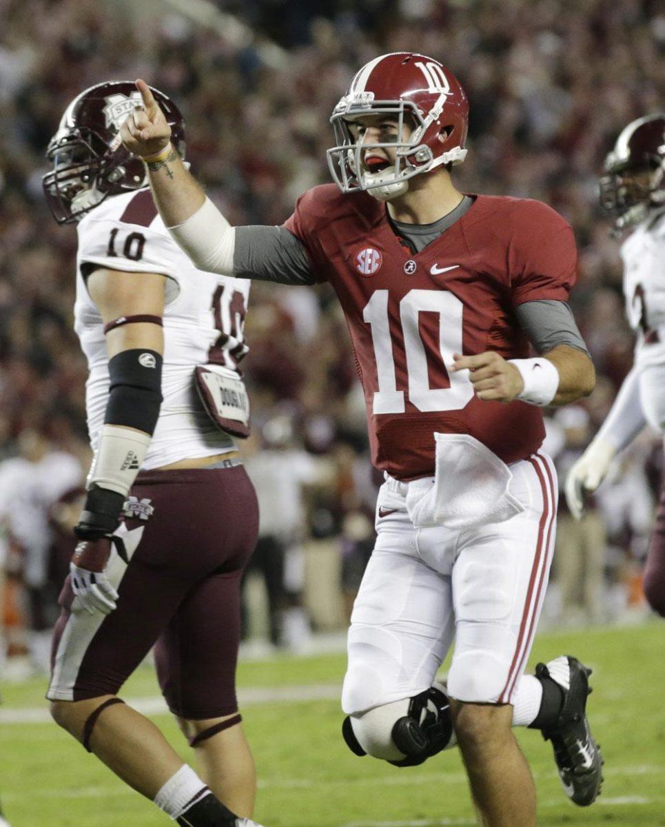 Alabama quarterback AJ McCarron (10) reacts after throwing a touchdown pass during the first half of an NCAA college football game at Bryant-Denny Stadium in Tuscaloosa, Ala., Saturday, Oct. 27, 2012. At left is Mississippi State linebacker Cameron Lawrence (10). (AP Photo/Dave Martin)