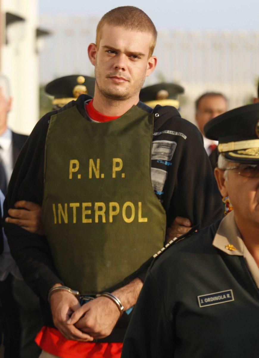 FILE - In this June 4, 2010, file photo, Dutch citizen Joran van der Sloot is escorted by police officers outside a Peruvian police station, near the border with Chile in Tacna, Peru. A Dutch newspaper said on Monday, Oct. 8, 2012, that Joran van der Sloot, who is serving a 28-year-sentence for murdering a young Peruvian woman, has impregnated a woman while imprisoned in Lima. (AP Photo/Karel Navarro, File)