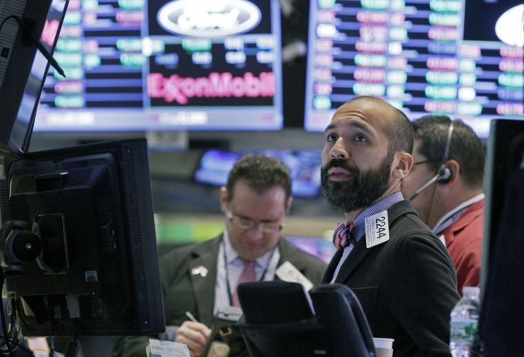 Specialist Fabian Caceres works at his post on the floor of the New York Stock Exchange Tuesday, Oct. 9, 2012. Another dire prediction about global economic growth is sending stocks lower on Wall Street in early trading. (AP Photo/Richard Drew)
 