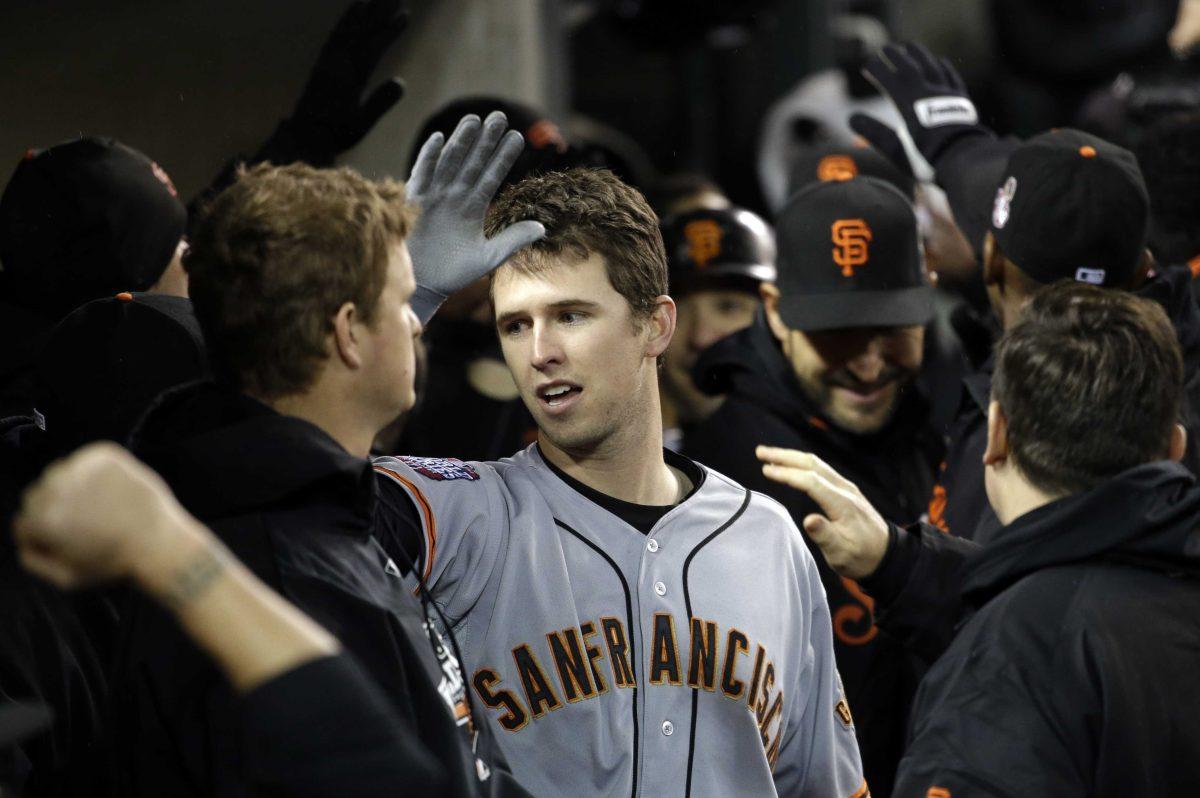 San Francisco Giants' Buster Posey celebrates in the dugout after hitting a two-run home run during the sixth inning of Game 4 of baseball's World Series against the Detroit Tigers Sunday, Oct. 28, 2012, in Detroit. (AP Photo/David J. Phillip)