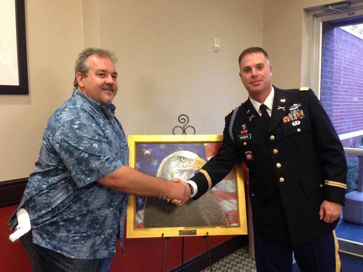 La. artist Tony Bernard (left) honors Capt. William Conger (right) with an oil-based painting for winning the 2012 Distinguished Military Honor Award.