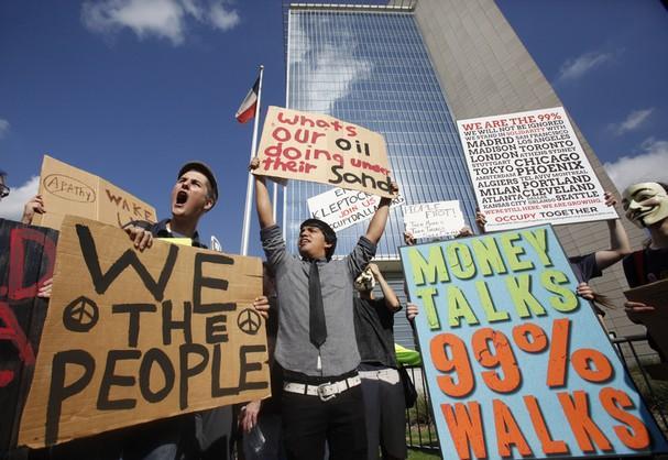 Protestors chant and holds signs on Oct. 6 outside the Federal Reserve Bank of Dallas building in downtown Dallas. Protestors across the state marched against the current state of the economy and corporate influence on the government.
 