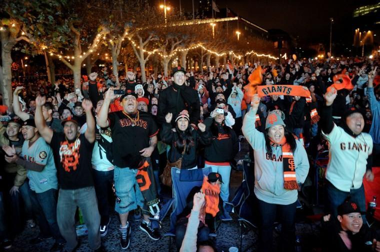 San Francisco Giants fans celebrate outside San Francisco's City Hall while watching a broadcast of the Giants facing the Detroit Tigers in Game 4 of baseball's World Series on Sunday, Oct. 28, 2012. The Giants won the game to sweep the series. (AP Photo/Noah Berger)
 