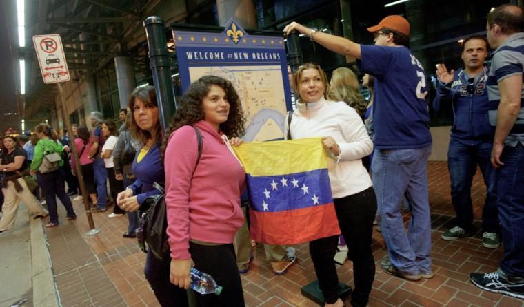 Mailyn Yoria, 19, and her mother Yelby Yoria of Miami, smile as they pose for a picture holding a Venezuelan flag as they wait in line to vote at the New Orleans Ernest Morial Convention Center, in New Orleans, Sunday, Oct. 7, 2012. Hundreds of Venezuelans living in the U.S. streamed into New Orleans on Sunday to cast ballots in the presidential election in their homeland, many of them determined to end the 13-year reign of Hugo Chavez. With the country's consulate in Miami closed, thousands of Venezuelans traveled by bus, car and plane to cast their votes at the consulate in New Orleans. (AP Photo/Matthew Hinton)
 