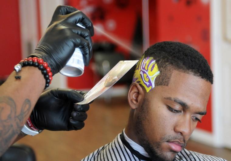 Paul Hernandez, a student at BRCC, gets the Eye of the Tiger cut and painted into his hair at Smashing the City Barbershop on September 26.
 